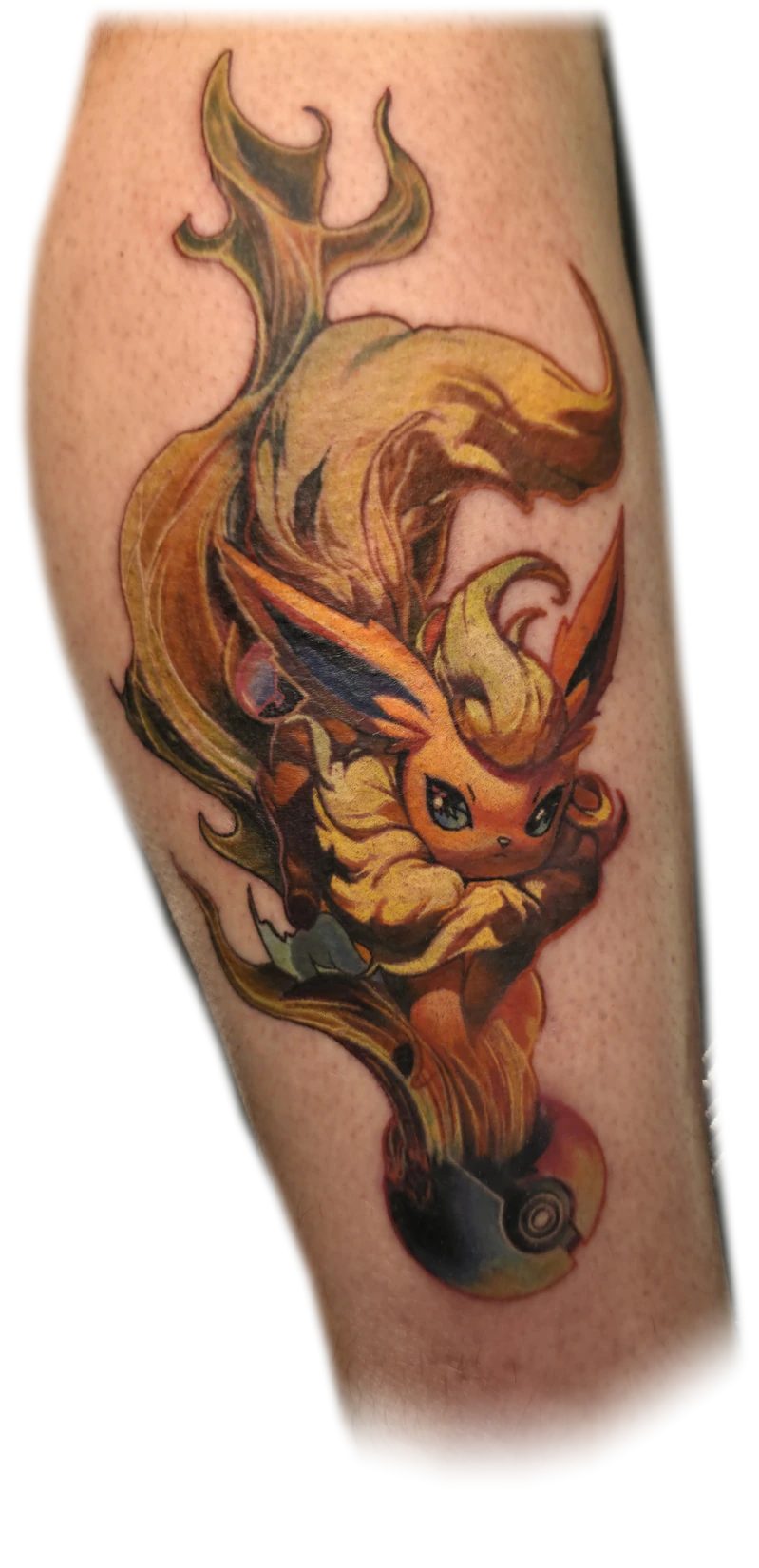 Colour Flareon tattoo with flowing flames on a lower leg, by Ben Bickley
