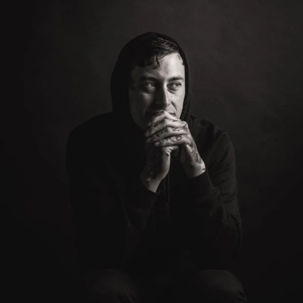 Portrait of Ben Bickley seated against a dark studio background